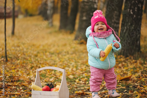 little girl with autumn harvest in park