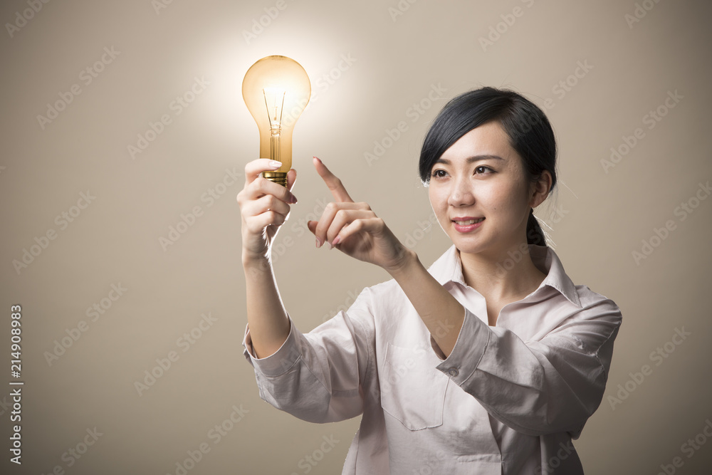 電球を持って微笑む若い女性