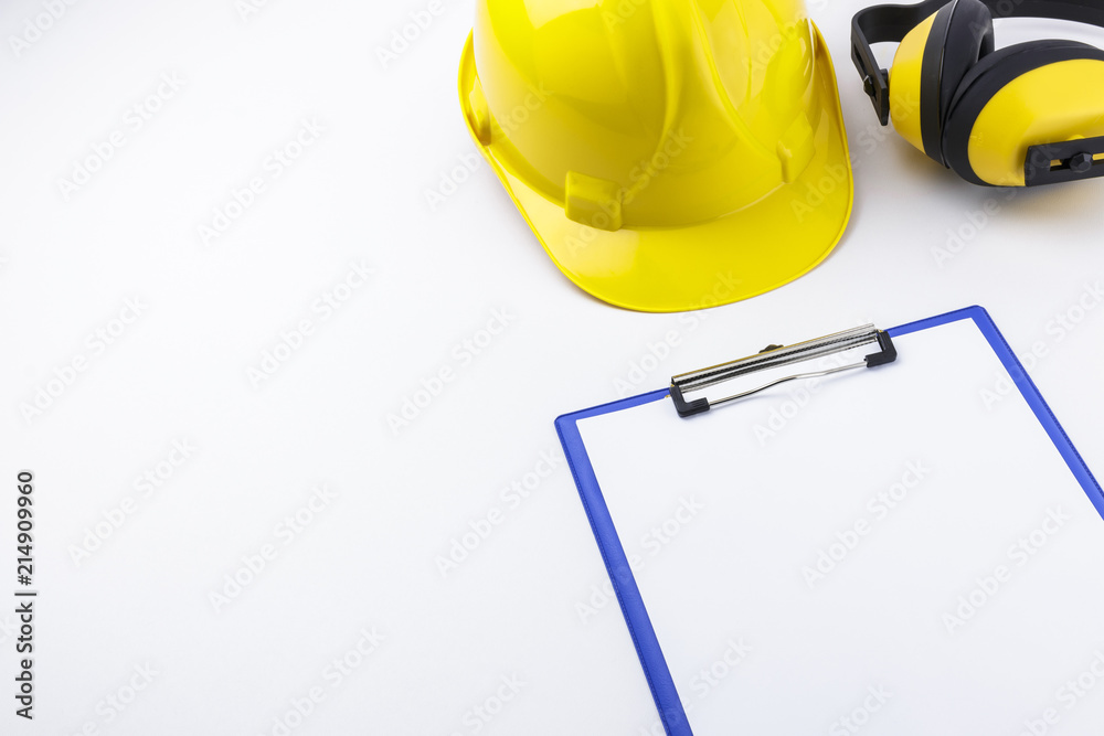 Hardhat, Earmuffs, and Clipboard on White Background with Copy Space Hardhat, Earmuffs, and Clipboard on White Background with Copy Space