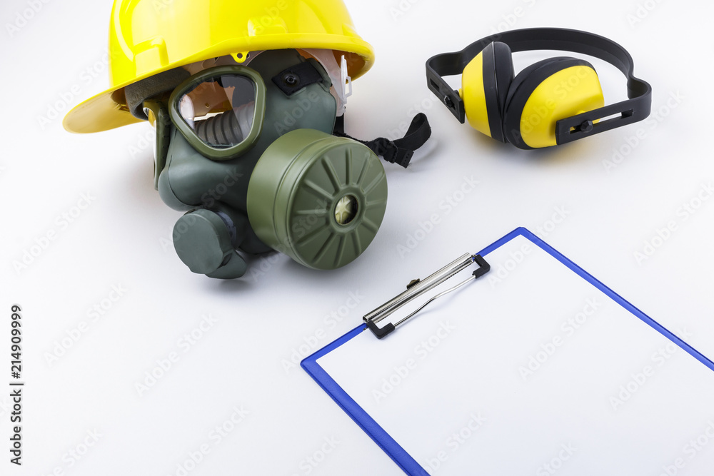 Gas Mask with Hard Hat Alongside Earmuffs and Clipboard White Background Gas Mask with Hard Hat Alongside Earmuffs and Clipboard White Background