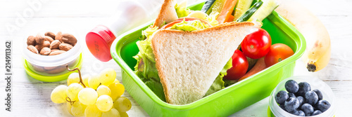Lunch box with sandwich, vegetables, banana, water, nuts and ber