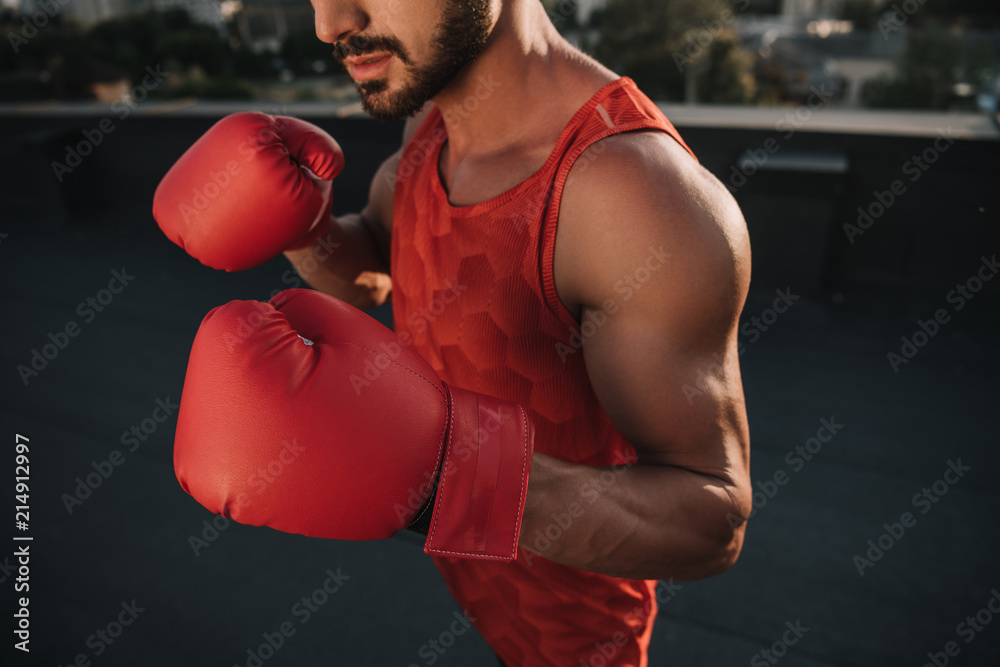 Fototapeta przycięty obraz treningu boksera z rękawicami bokserskimi na dachu