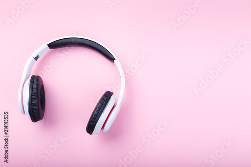 White modern headphones on trending pink backgound flat lay top view space for text