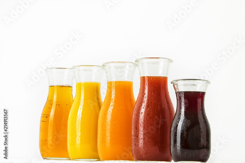 unterschiedliche Fruchtsäfte in Glasflaschen vor weissem Hintergrund, Freisteller