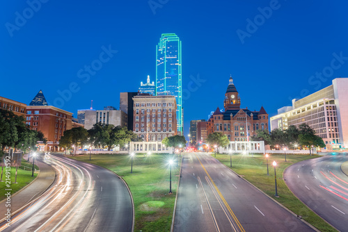 Beautiful view of Dallas skyscrapers and light trail traffic over Dealey Plaza, JKF assassination site. Skyline and transportation cityscape at blue hour photo