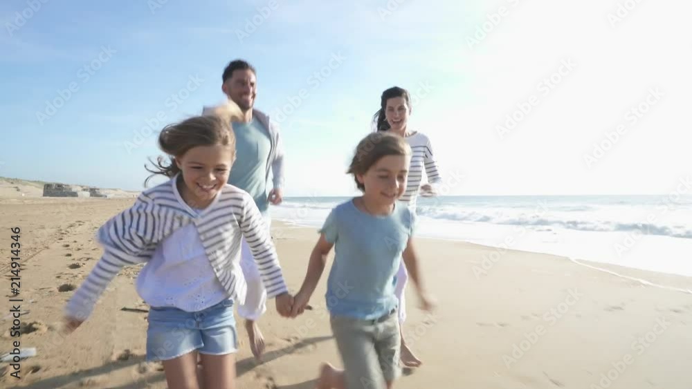 Family walking on sandy beach at sunset Family walking on sandy beach at sunset