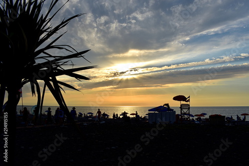 Beautiful sunset over the Black sea. Beach with palm trees in Batumi, Georgia