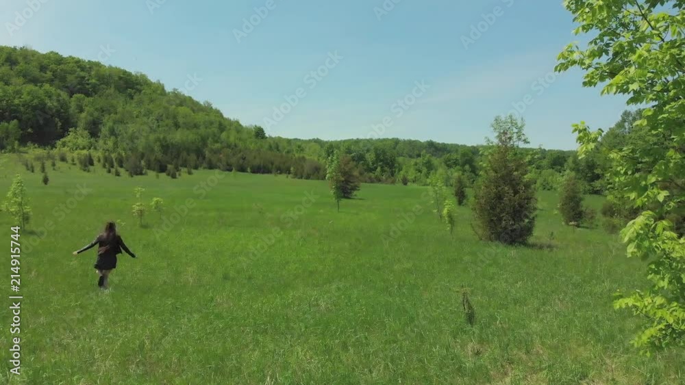 Young woman running skipping through field in school clothes. Young woman running skipping through field in school clothes.
