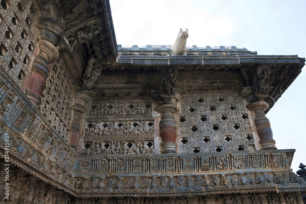 Ornate perforated window and Madanikas, Salabhanjika meaning celestial damsels, on top of the pillars. Chennakeshava temple, Belur, Karnataka.