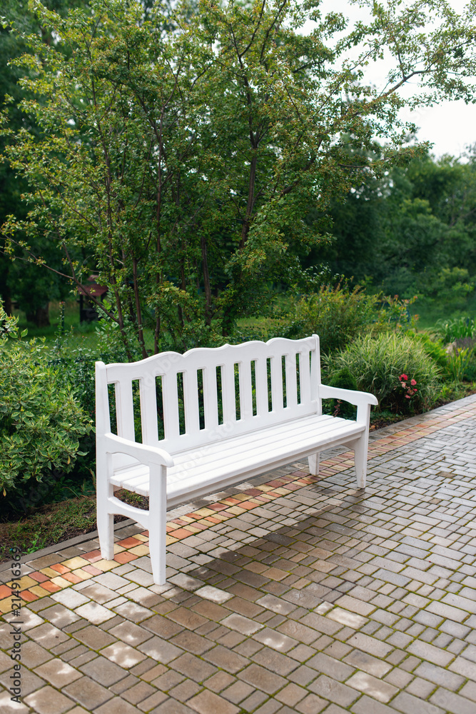 Lounge area for guests outside. Wedding decor. White bench in the park Lounge area for guests outside. Wedding decor. White bench in the park