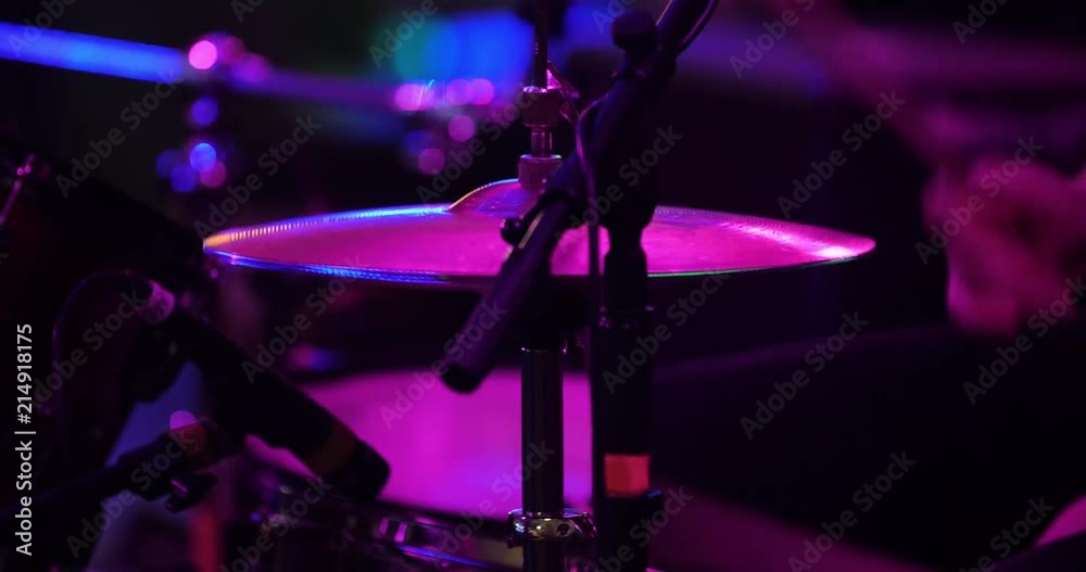Cymbals on a drum set close up being played by drummer on stage