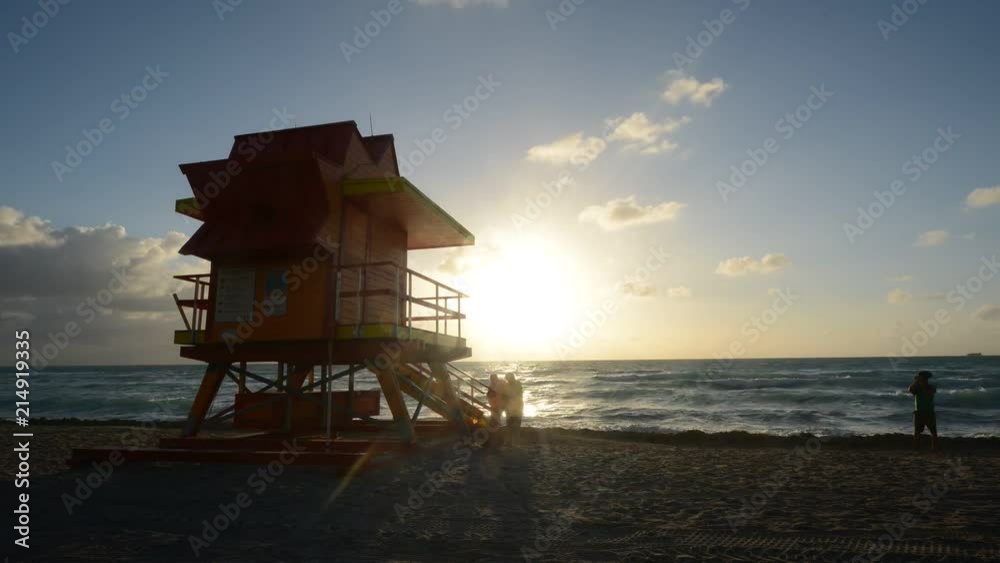 Time lapse of people at sunrise on Miami beach with lifeguard tower in Florida, USA Time lapse of people at sunrise on Miami beach with lifeguard tower in Florida, USA