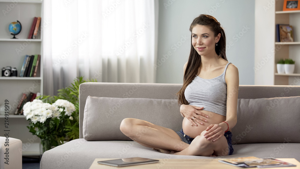 Happy future mother touching belly feeling movement inside, healthy pregnancy Happy future mother touching belly feeling movement inside, healthy pregnancy
