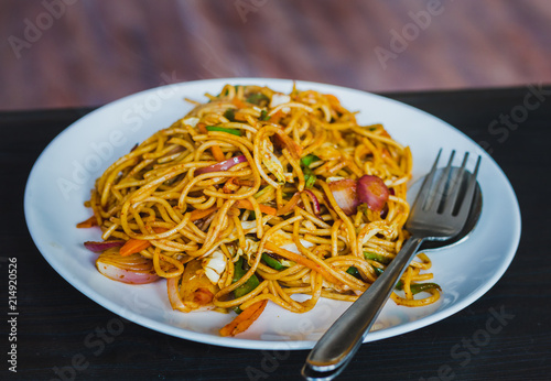 Chinese Noodles, Chowmein on a Plate with Spoon and Fork photo