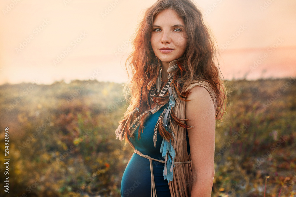 Obraz premium beautiful pregnant woman on a field at sunset