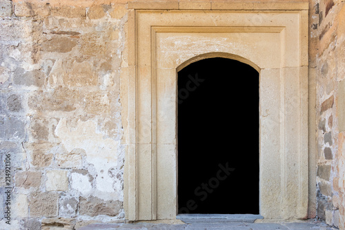 A door in a stone wall is isolated on a black background with copy space © Viktor Fedorenko