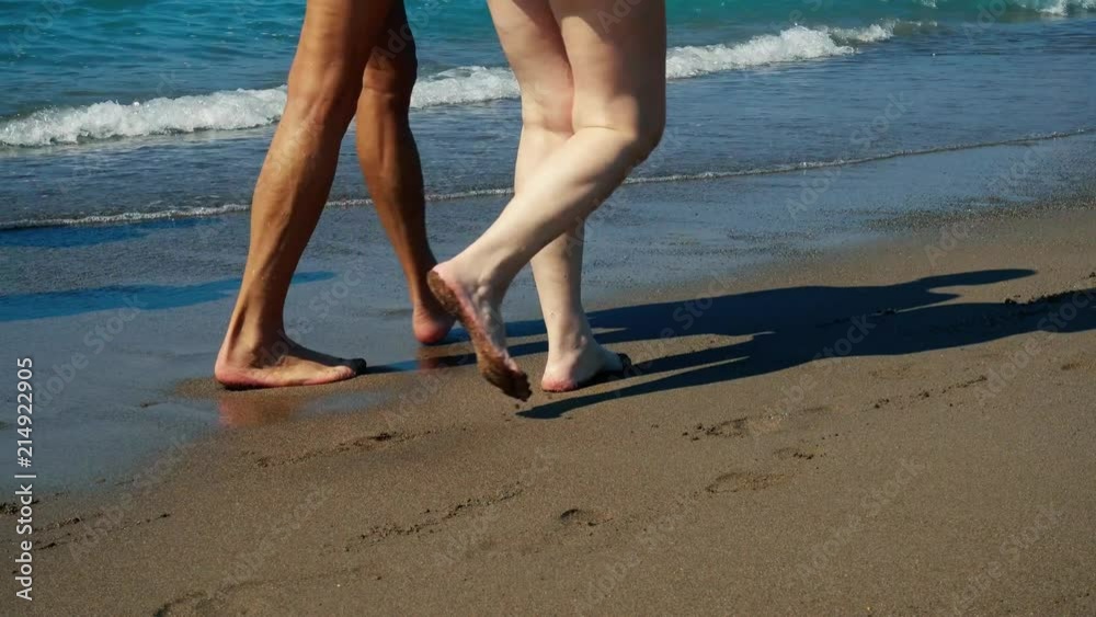 The waves run to the shore. Sand beach. The feet of walking people. The waves run to the shore. Sand beach. The feet of walking people.
