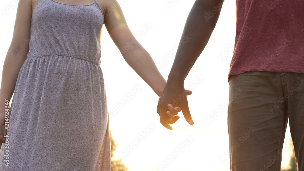 Boyfriend and girlfriend firmly clasp hands on sunset background, together Boyfriend and girlfriend firmly clasp hands on sunset background, together