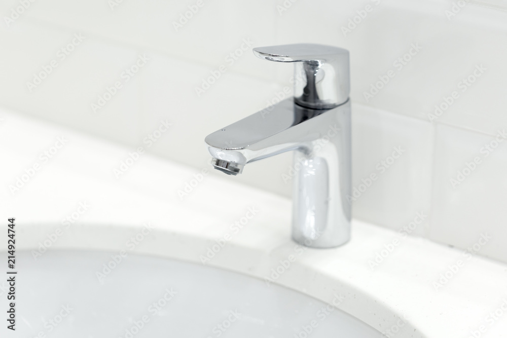 chrome crane on the ceramic wash basin in the bathroom close up chrome crane on the ceramic wash basin in the bathroom close up