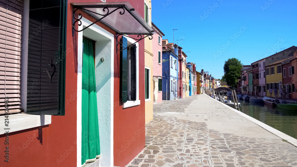 Beautiful street with multicolored houses in Burano attracting to walk, Venice