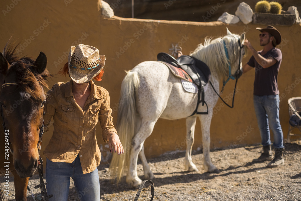 couple in countryside prepare horses to go outdoor traveling and discover new plces in excursion. ntaural outdoor lifestyle for happiness and pet therapy couple in countryside prepare horses to go outdoor traveling and discover new plces in excursion. ntaural outdoor lifestyle for happiness and pet therapy