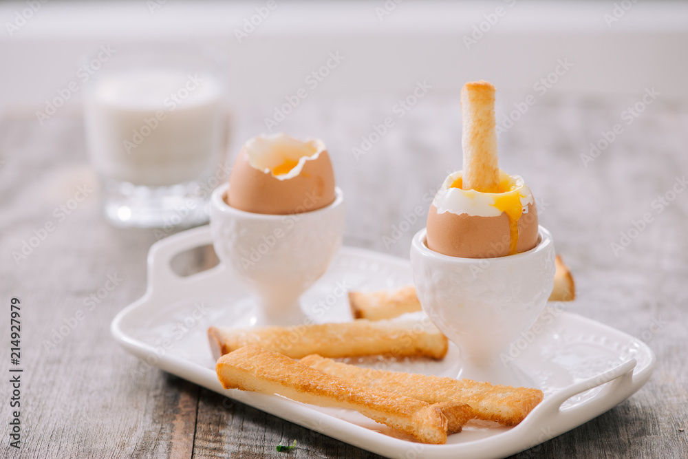 Fototapeta premium delicious breakfast with soft boiled eggs and crispy toasts, closeup