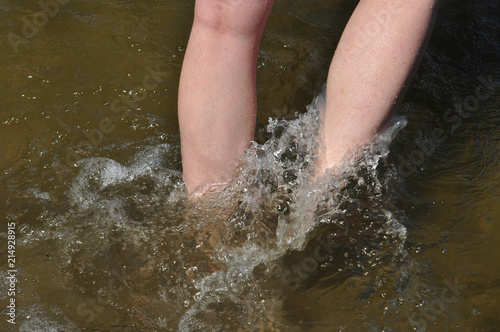 Frauenbeine, mit den Füßen im Wasser  photo