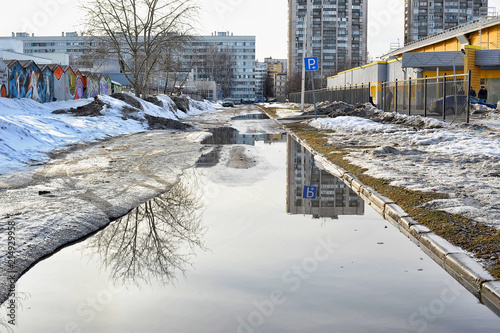 Slush, puddles and melting snow on a city street in the spring photo