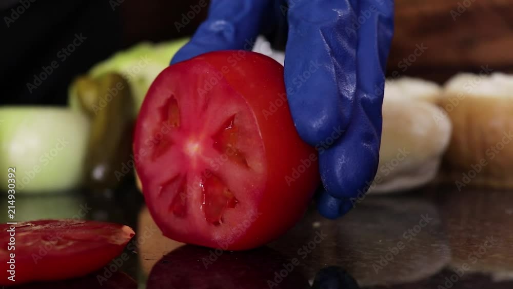 Fresh tomato being sliced on marble top Fresh tomato being sliced on marble top