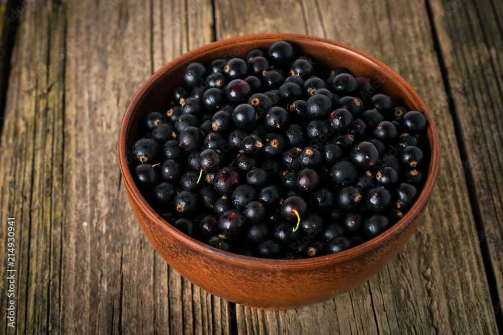 Black currant on wooden table with leaf sprig Black currant on wooden table with leaf sprig