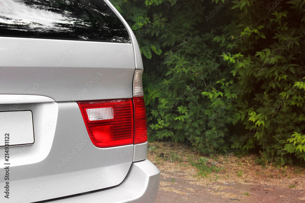 Part of a gray car on a forest background. Luxury Headlights Part of a gray car on a forest background. Luxury Headlights