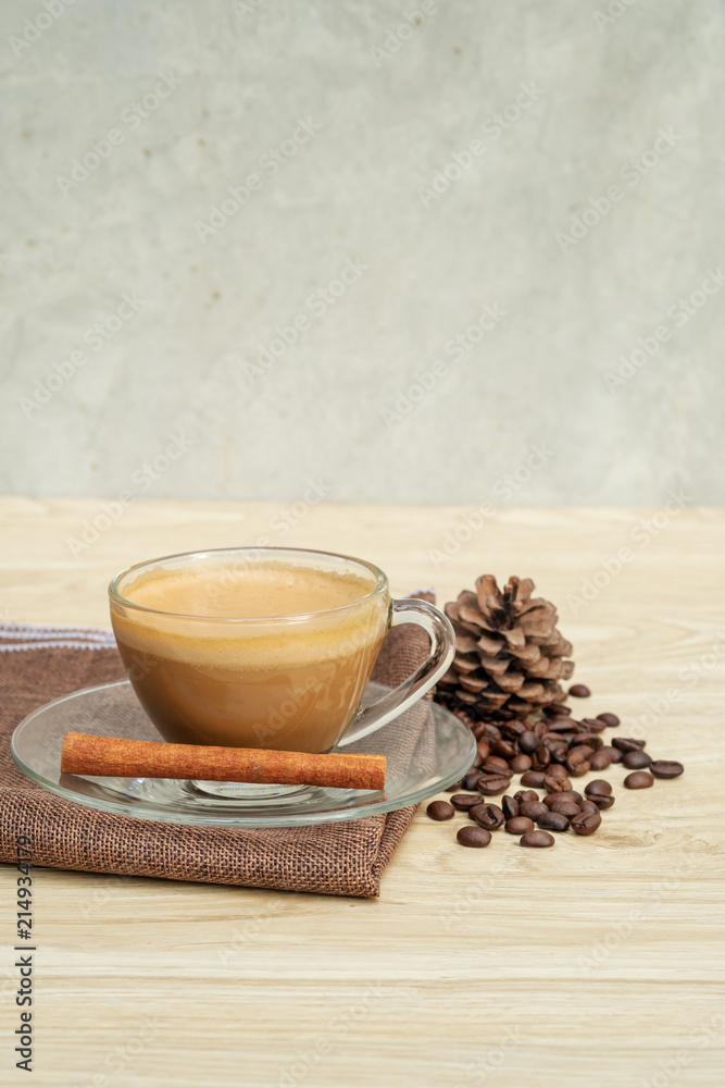 A cup of hot coffee and cinnamon on a wooden table. A cup of hot coffee and cinnamon on a wooden table.