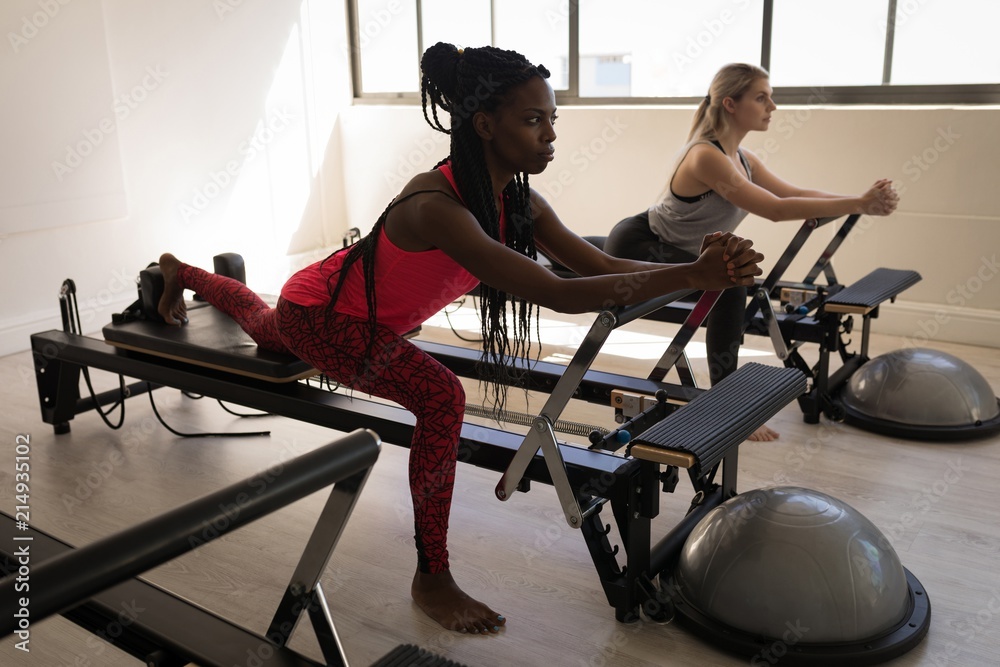 Two women exercising on stretching machine Two women exercising on stretching machine