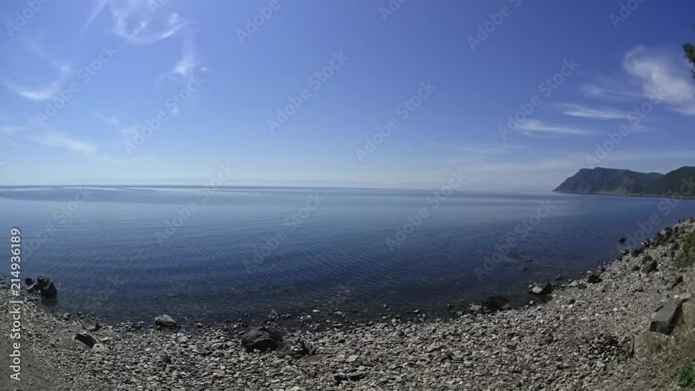 Timelapse, easy movement of white clouds in summer under the bright sun against the background of a clean and large lake Timelapse, easy movement of white clouds in summer under the bright sun against the background of a clean and large lake
