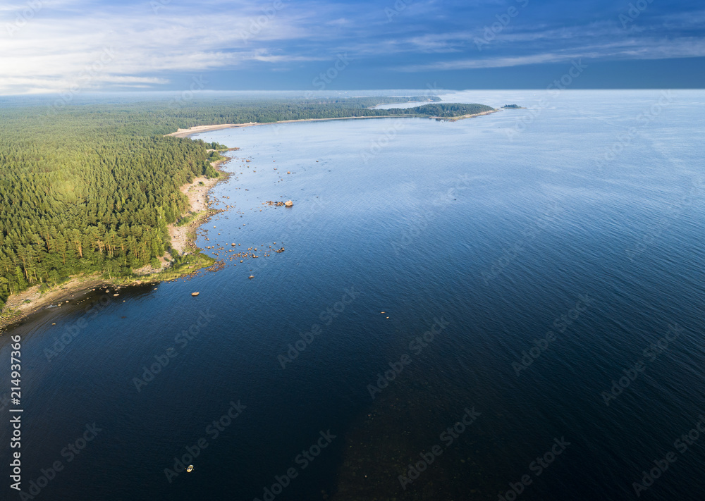 Aerial view of seashore with beach, lagoons and coral reefs. Coastline with sand and water. Tropical landscape. Aerial photography. Birdseye. Sea, beach, sky, clouds.
