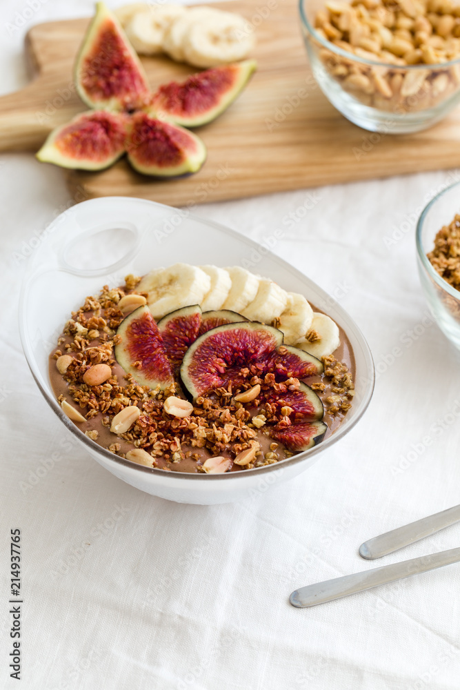 Peanut-butter banana, chocolate smoothie bowl decorated banana slice, fresh figs and nuts. Peanut-butter banana, chocolate smoothie bowl decorated banana slice, fresh figs and nuts.