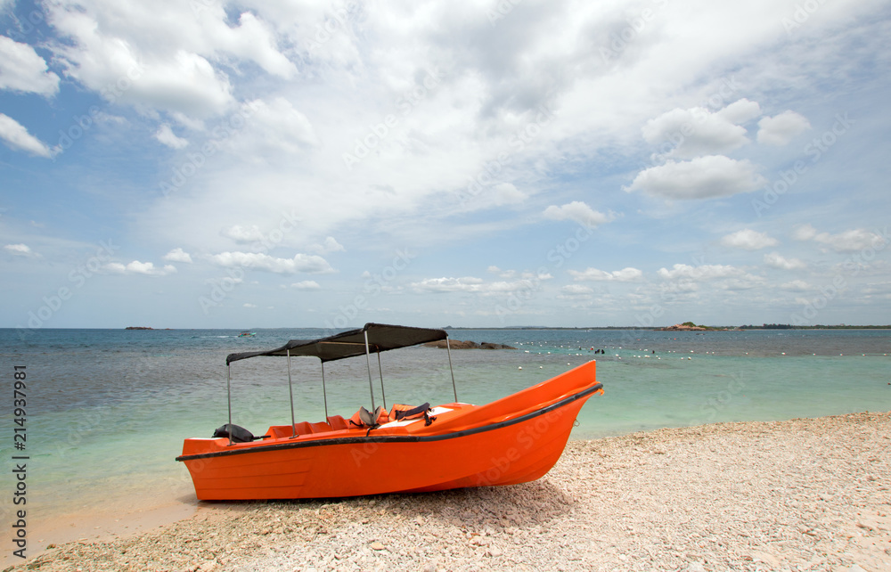 Bright orange panga / fishing boat on coral beach in Sri Lanka Asia