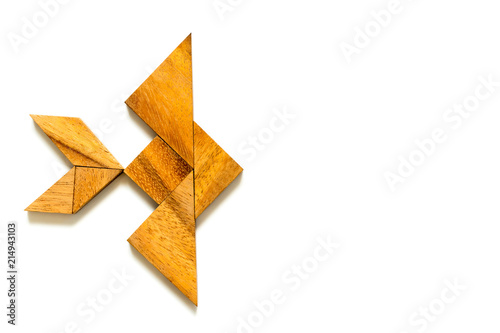 Wood tangram puzzle in swimming fish shape on white background