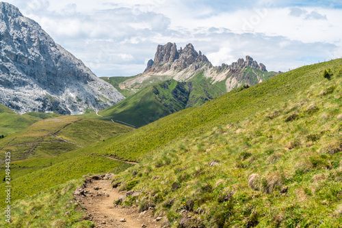 Italian Dolomites Landscape. Light after rain in Dolomites. Rocky peaks in the background surrounded by rain clouds. Mountain valley with layers of forest and mountains. Aerial view path trail hikeing