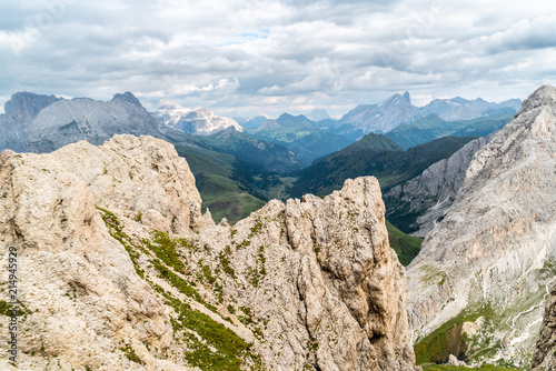 Panoramic view of a climber standing on the top of cliff in Dolomites Mountains. Italian Dolomites. Panoramic view of man walking on the ridge of the rocky mountains. 