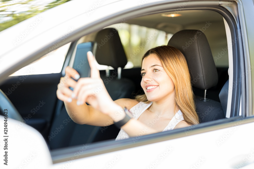 Woman taking selfie in her new car