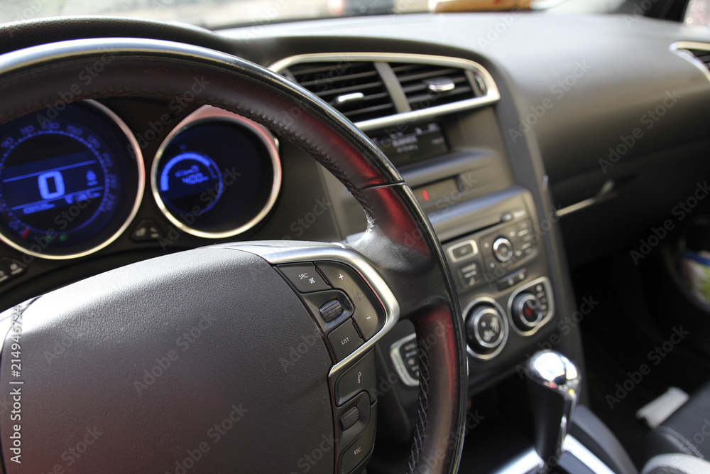 Steering wheel on the black car dashboard