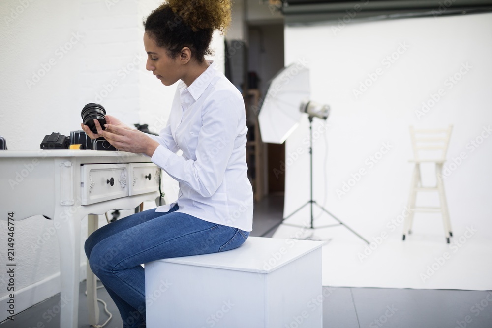 Female photographer checking camera lens