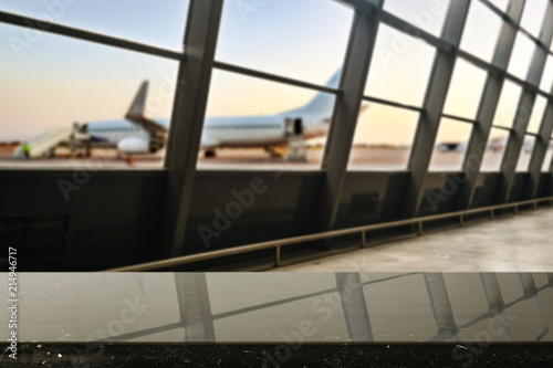 Wooden desk of free space and airport background with big window 