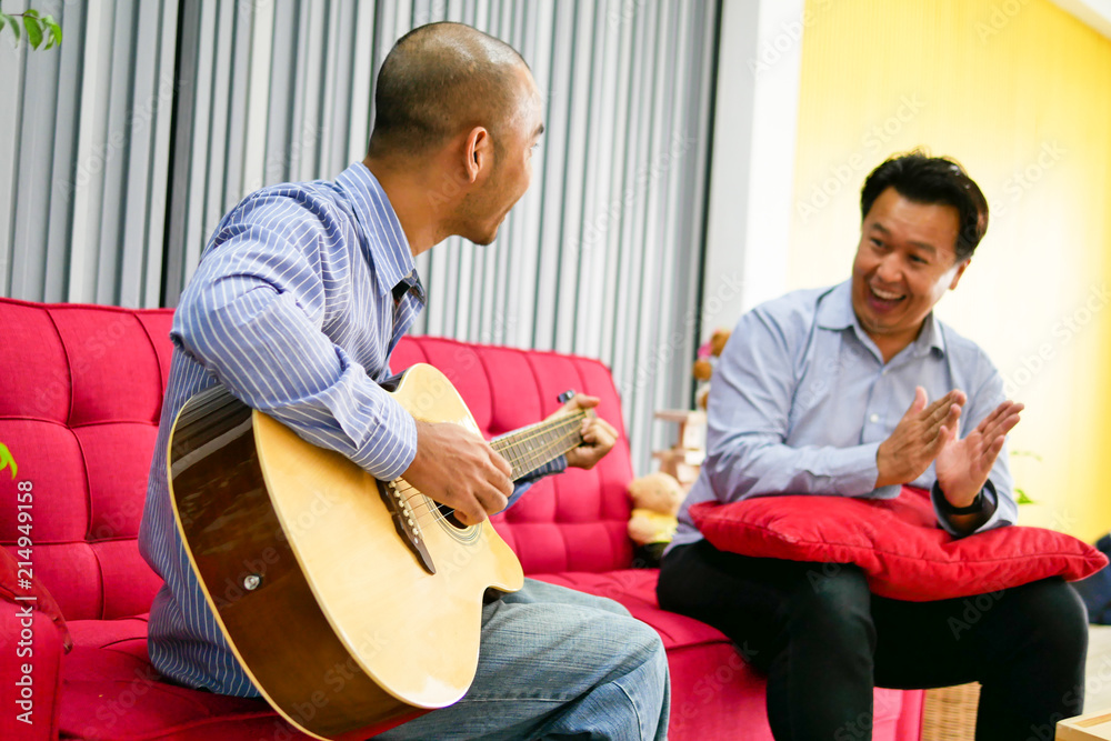 Two asian guys are playing guitar, music instrument for happy and smile feeling.