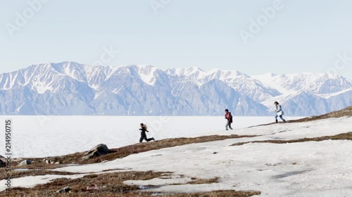 Kids running on the hill side of Pond Inlet, Nunavut photo