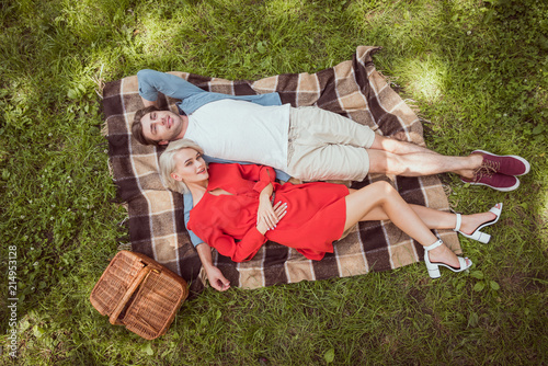 high angle view of girlfriend and boyfriend lying on blanket in park