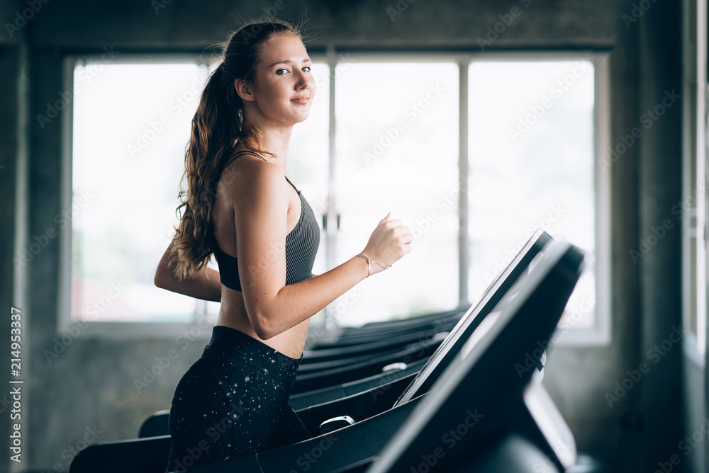 woman running on treadmill in gym