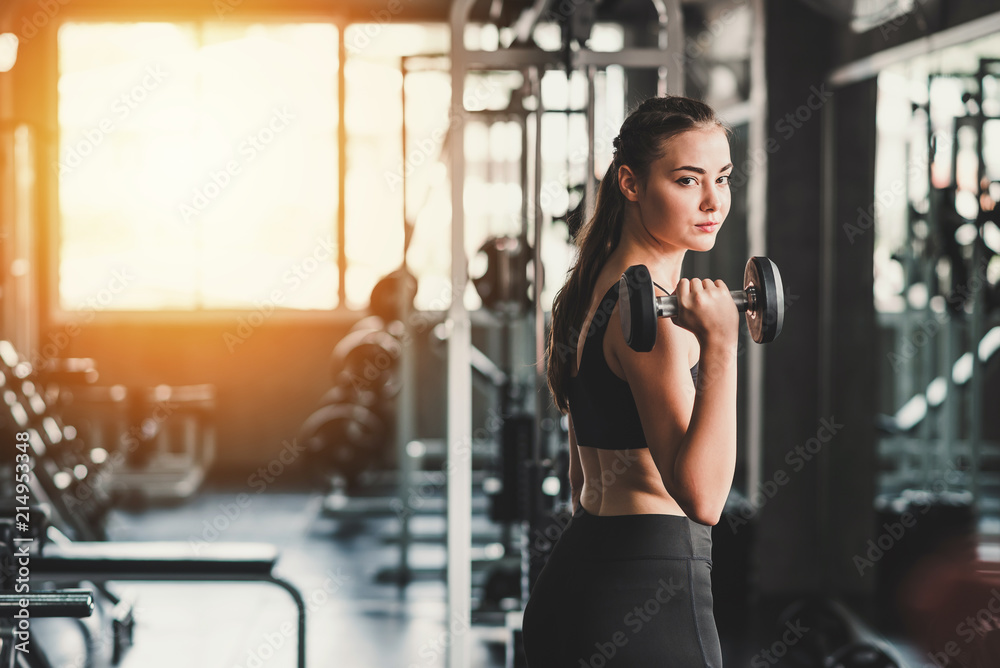 Woman holding dumbbell in gym
