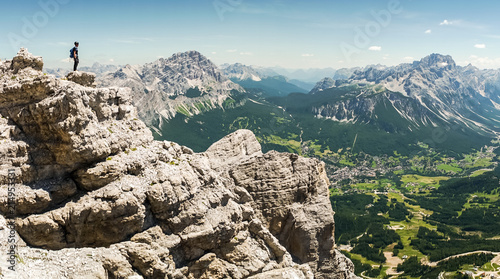 Climbers silhouette standing on a cliff in Dolomites. Tofana di Mezzo, Punta Anna, Italy. Man Celebrate success on top of the mountain Hiker standing on rocky ridge and enjoying the view in Dolomites